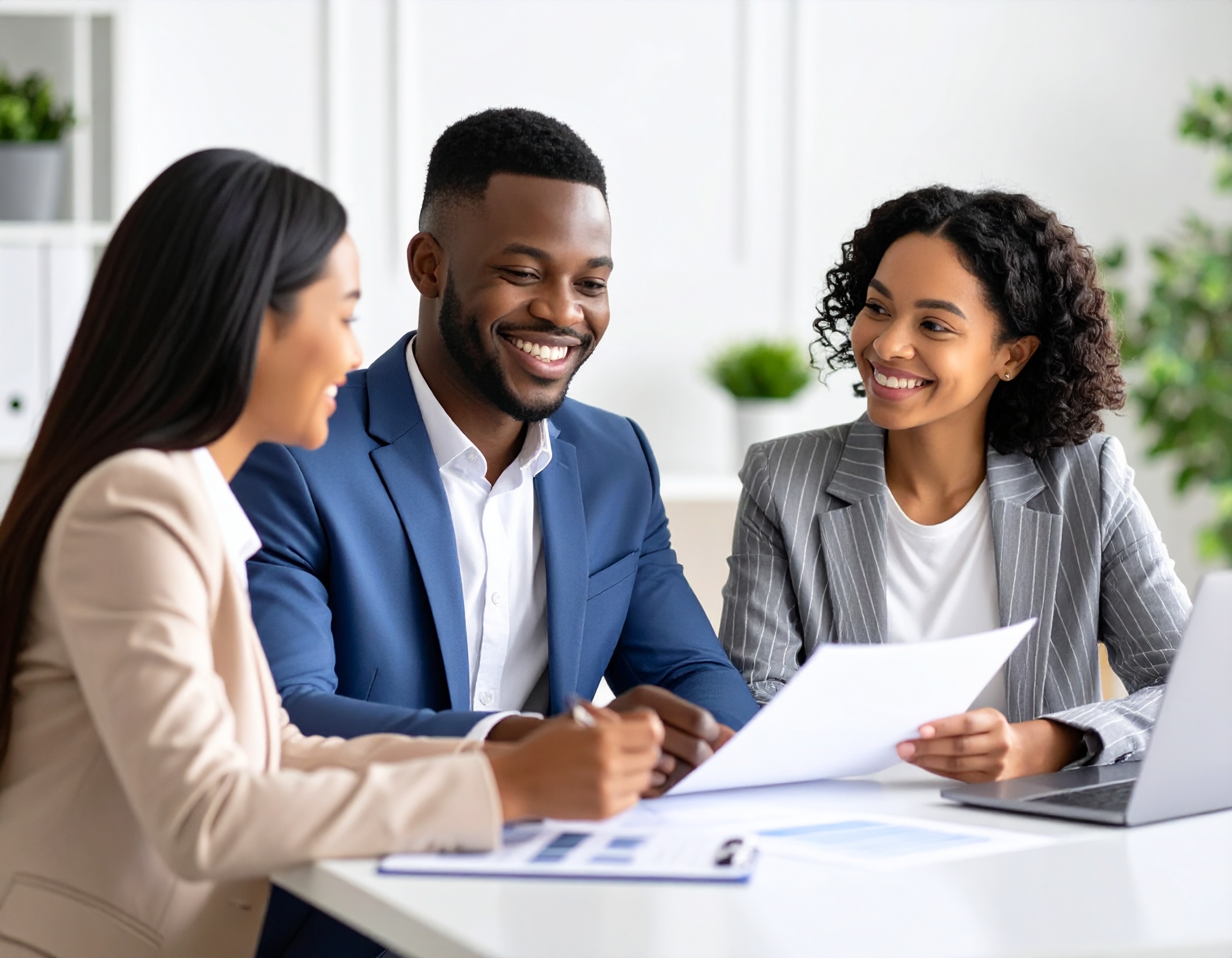 Letting agent reviewing tenancy application documents with a young professional couple, symbolising thorough tenant referencing services from Delisa Miller
